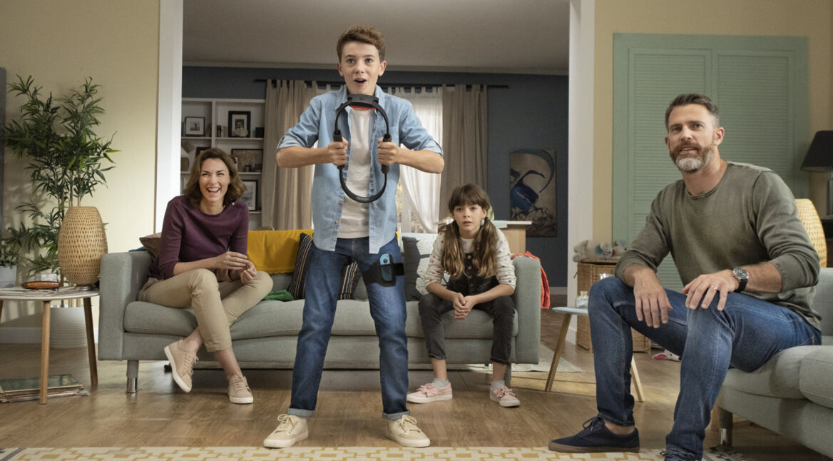 Junge spielt mit seiner Familie Ring Fit Adventure im Wohnzimmer