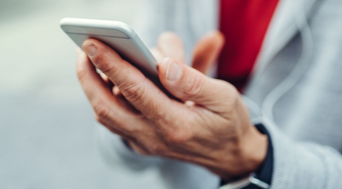 Mann hält ein Smartphone