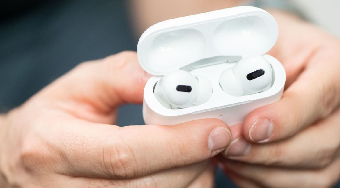Die AirPods Pro von Apple in der Hand halten.