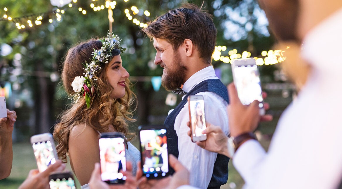 Gäste fotografieren ein Brautpaar