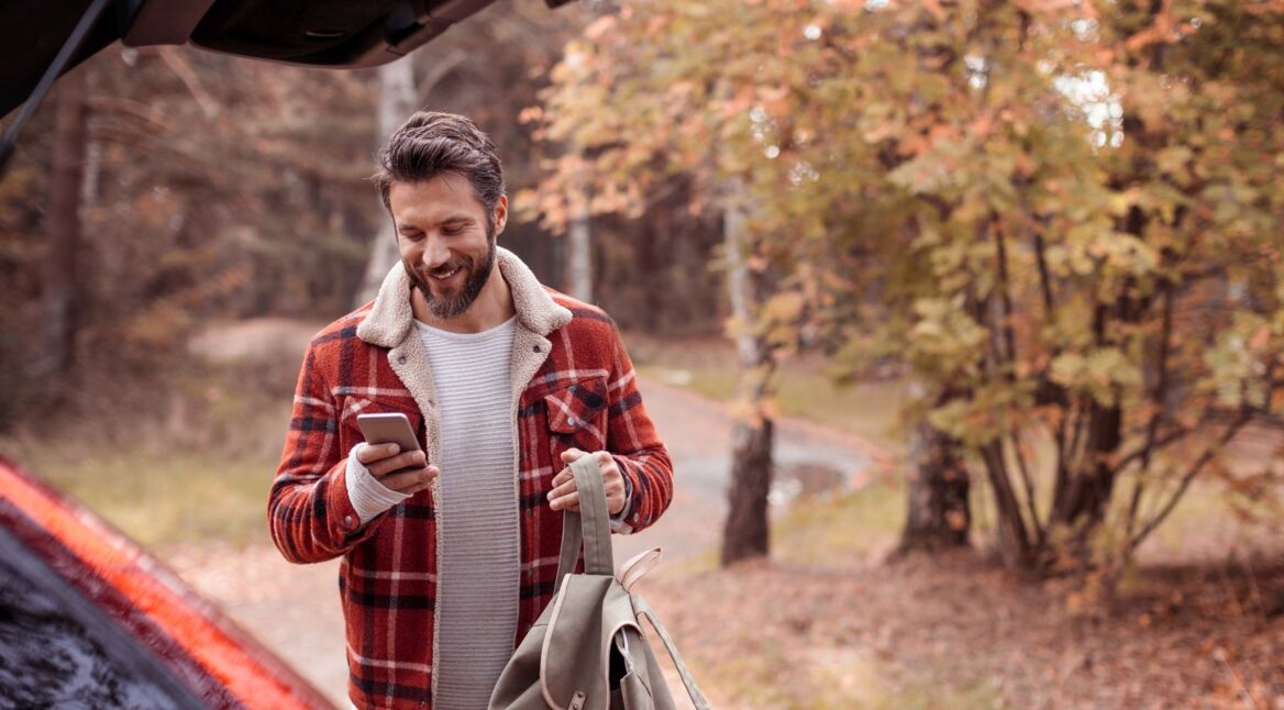 Junger Mann lädt Android 10 auf sein Samsung-Smartphone.