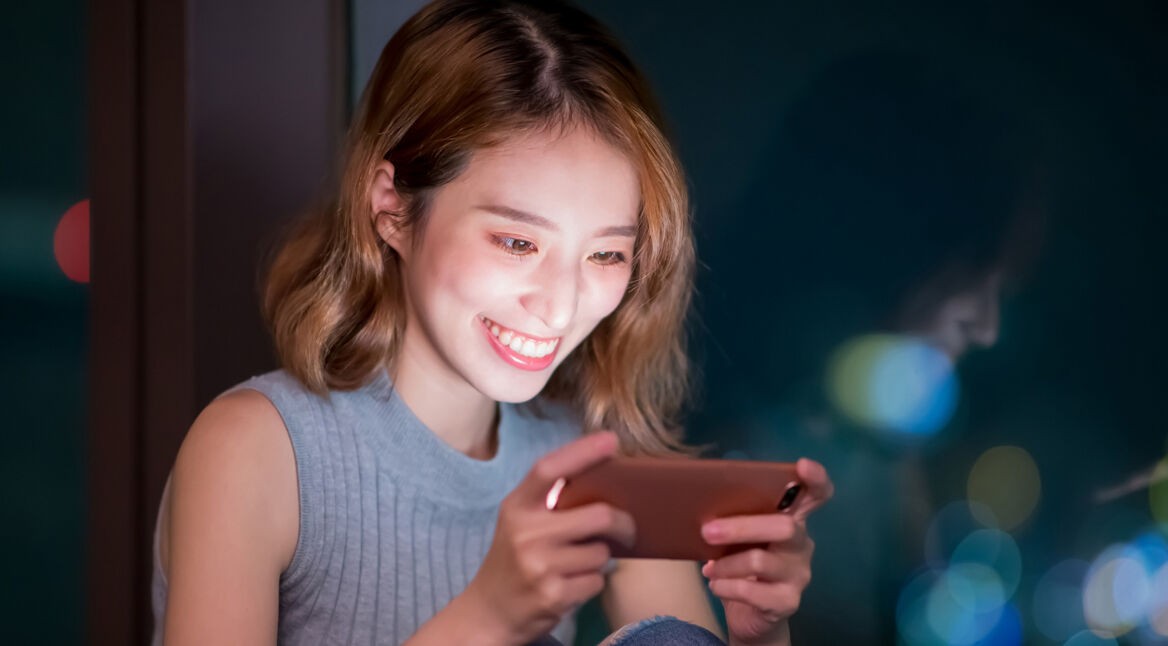 Frau spielt auf Smartphone