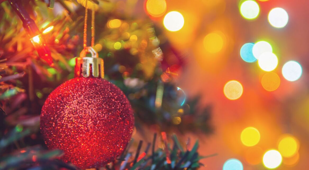 Rote Kugel hängt im Weihnachtsbaum.