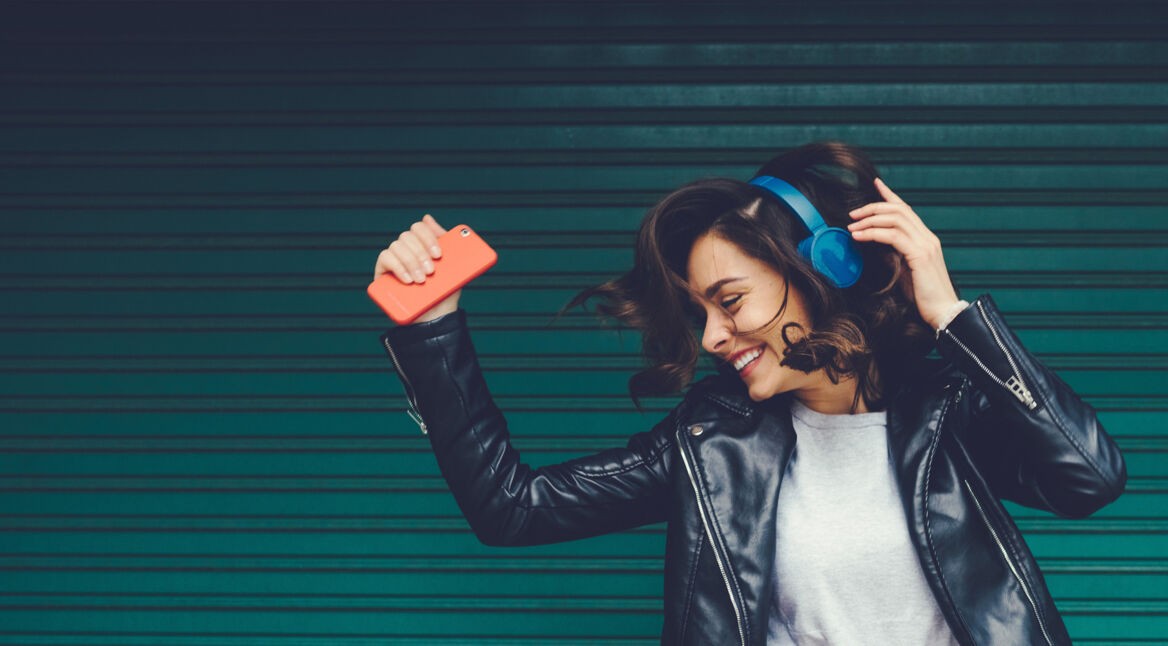 Frau mit Kopfhörer und Smartphone