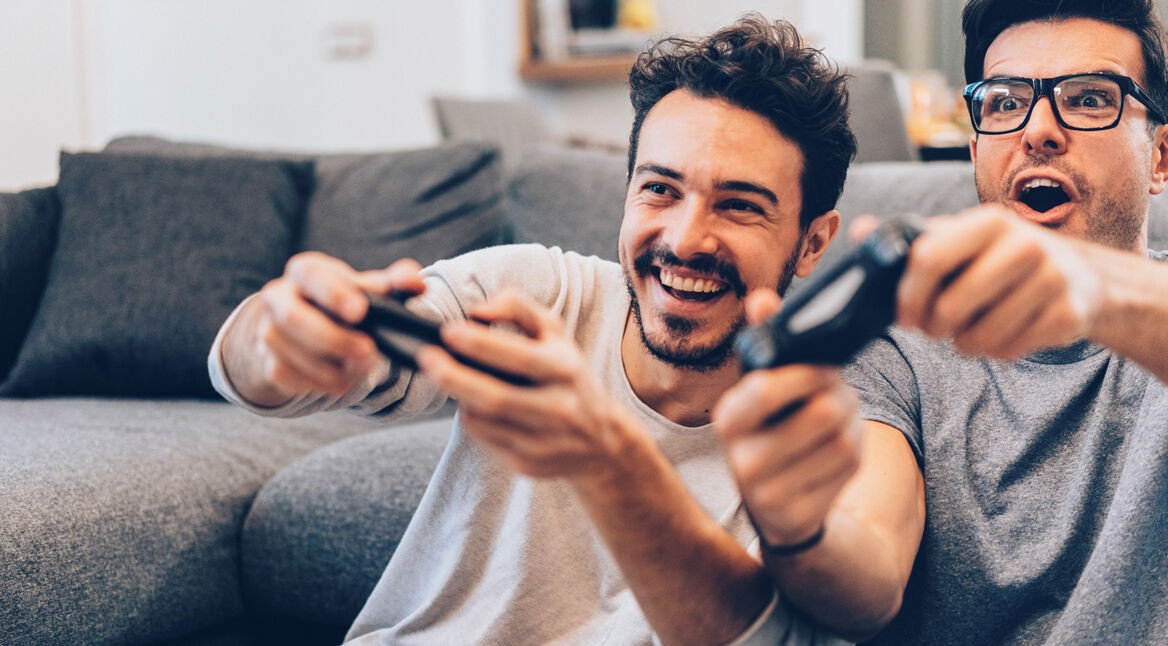 Zwei Männer zocken an der Konsole