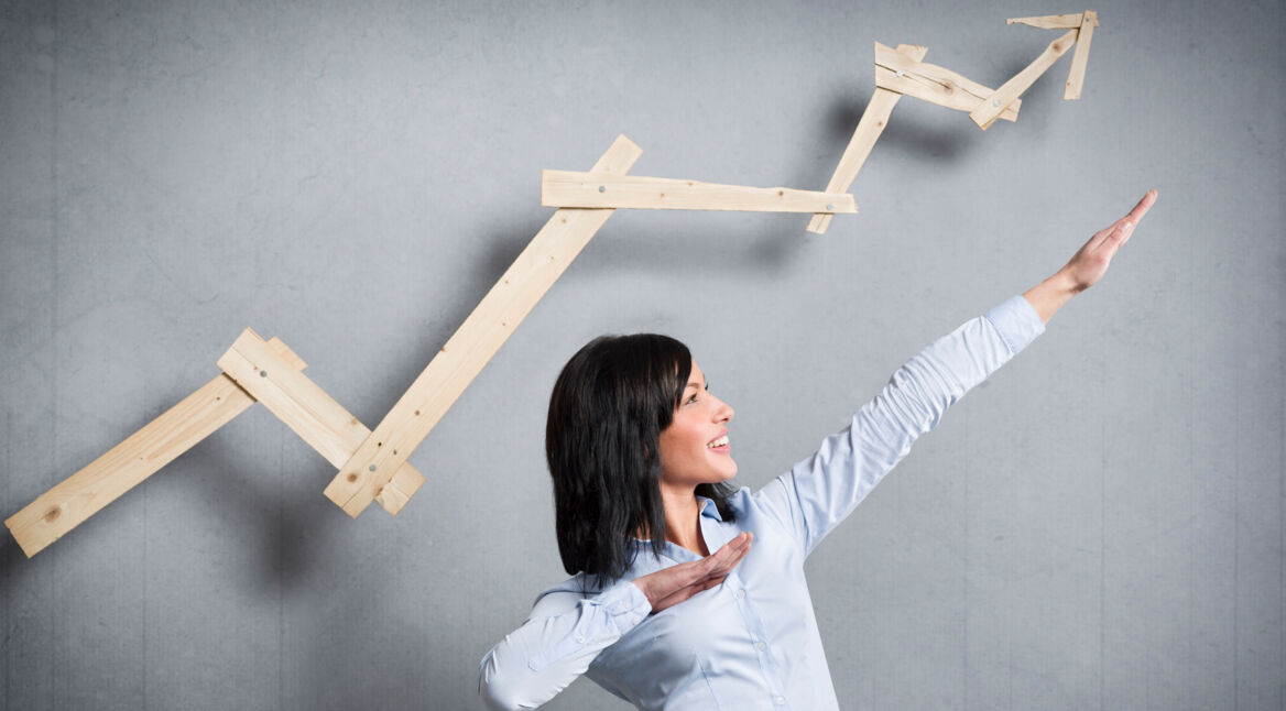 Excited businesswoman in front of pointing up business chart.