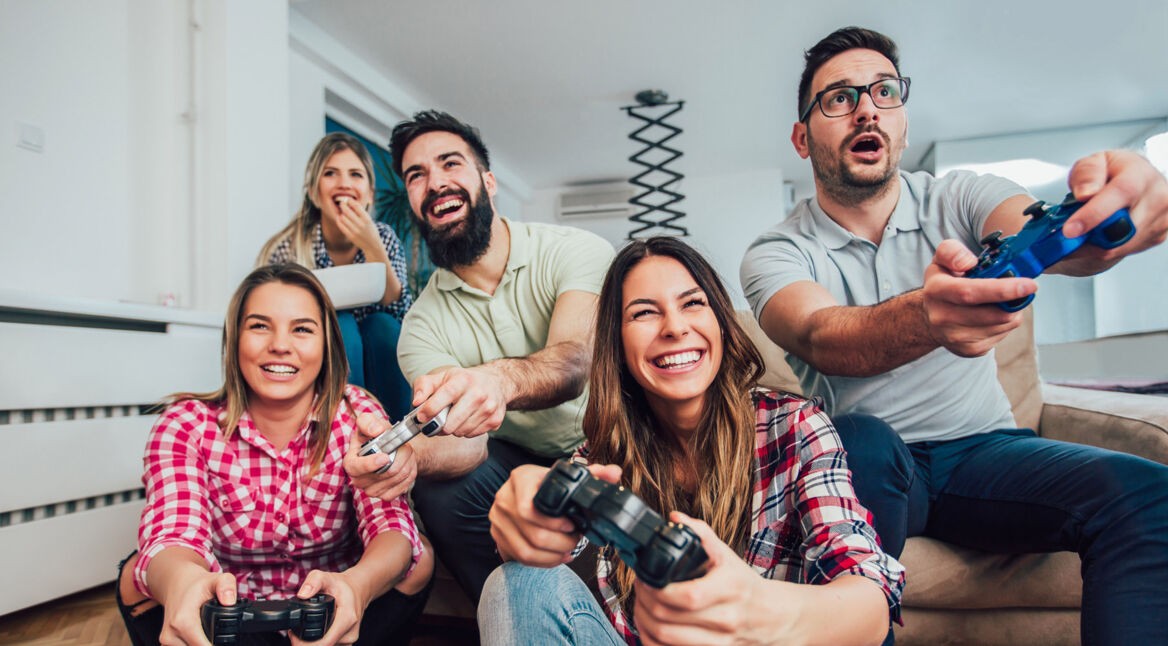 Group of friends play video games together.