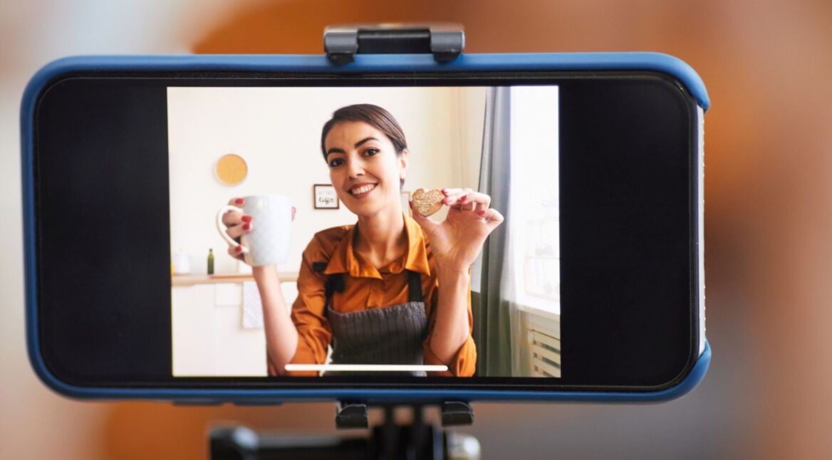 Eine Frau steht im Wohnzimmer und lächelt.