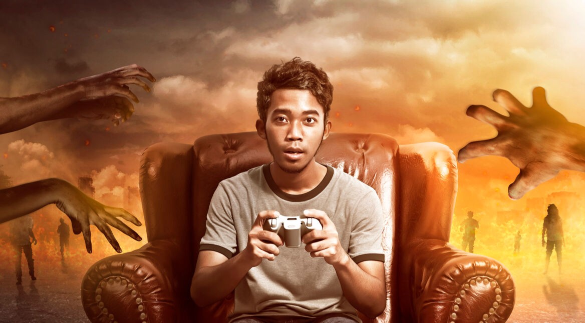 Mann auf Sessel mit Gamepad