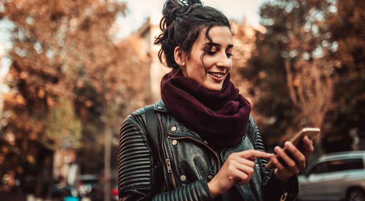 Frau schaltet den Dark Mode von WhatsApp am Smartphone ein.