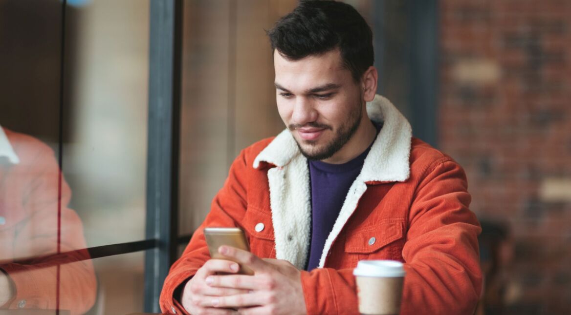 Mann teilt am Smartphone mit Google Chrome eine Webseite.