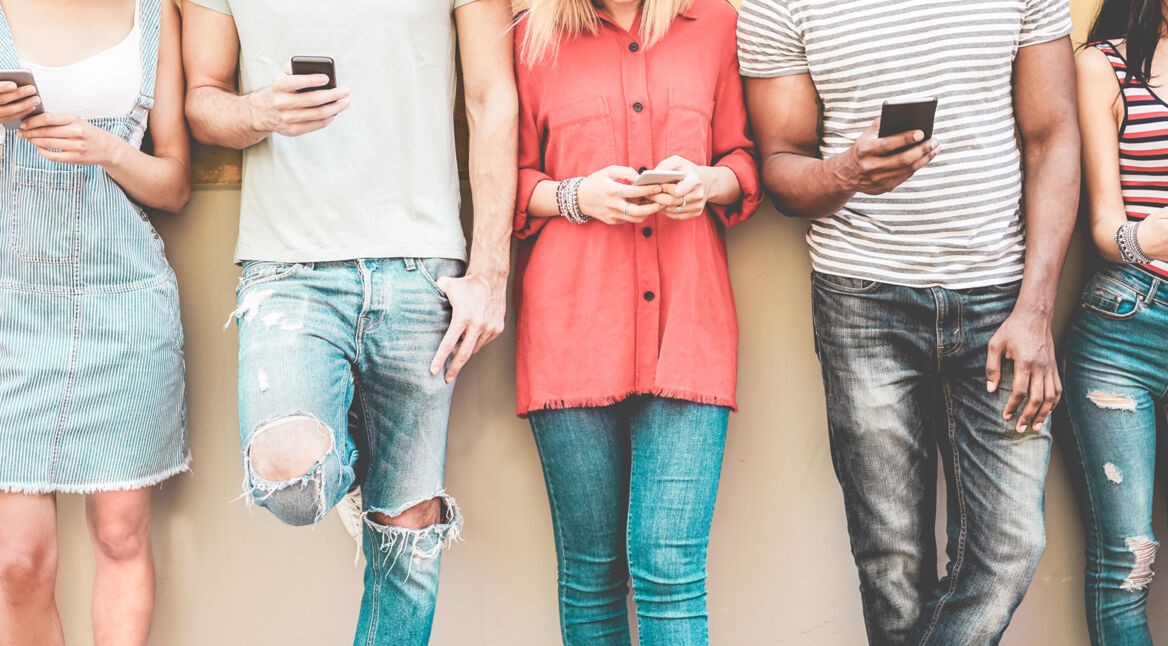 Smartphone Trends 2020: Junge Leute stehen mit Smartphone nebeneinander