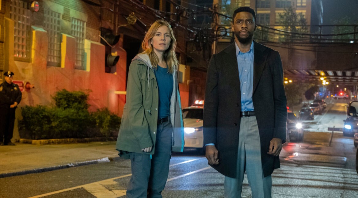 Detective Andre Davis und die Drogenfahnderin Frankie Burns stehen in 21 Bridges Filmkritik erschrocken auf der Straße. Foto: Concorde Filmverleih GmbH