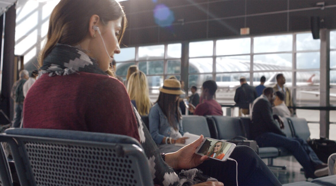 Frau schaut am Flughafen Netflix
