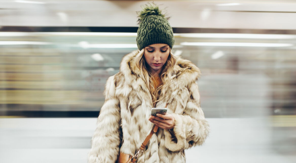 junge Frau schaut auf ihr Handy