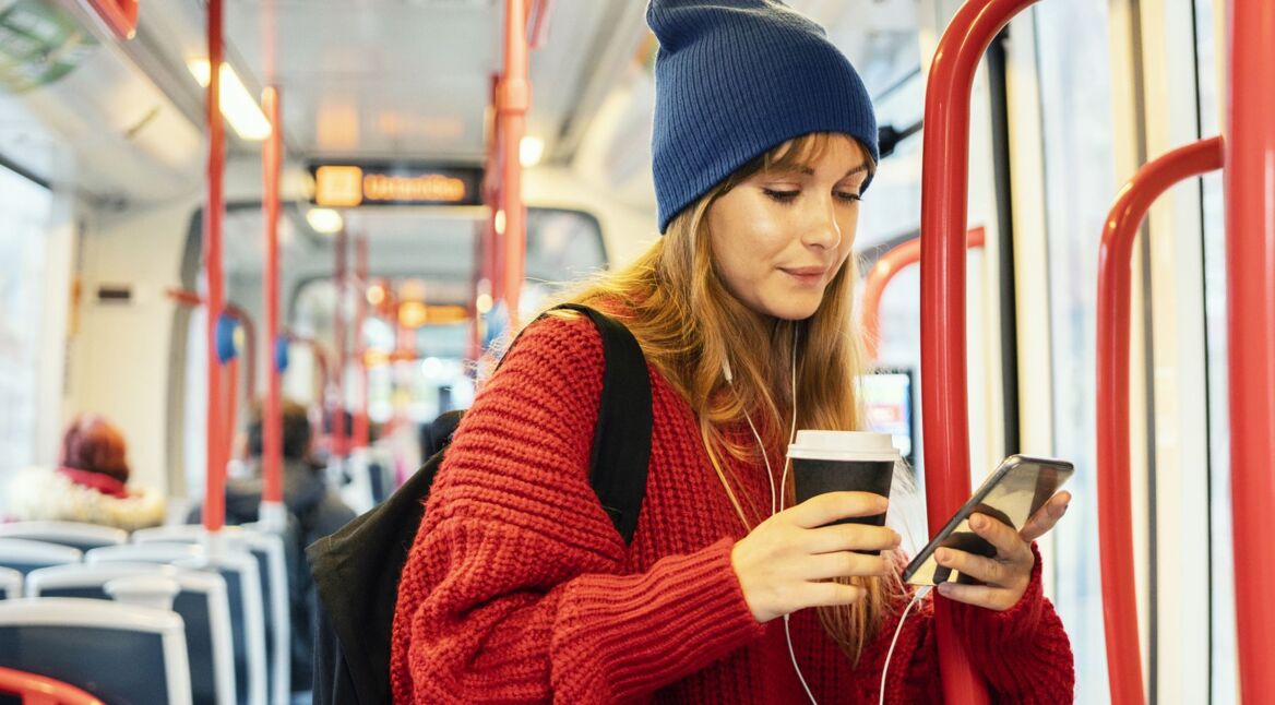 Frau öffnet den Musikplayer unter Android 11 am Handy.