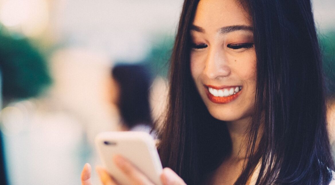 Frau öffnet den neuen Facebook Messenger am Handy.