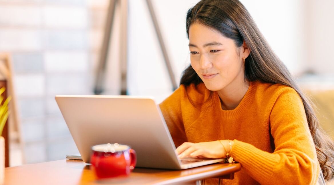 Frau klickt am Laptop auf WhatsApp Web Shortcut