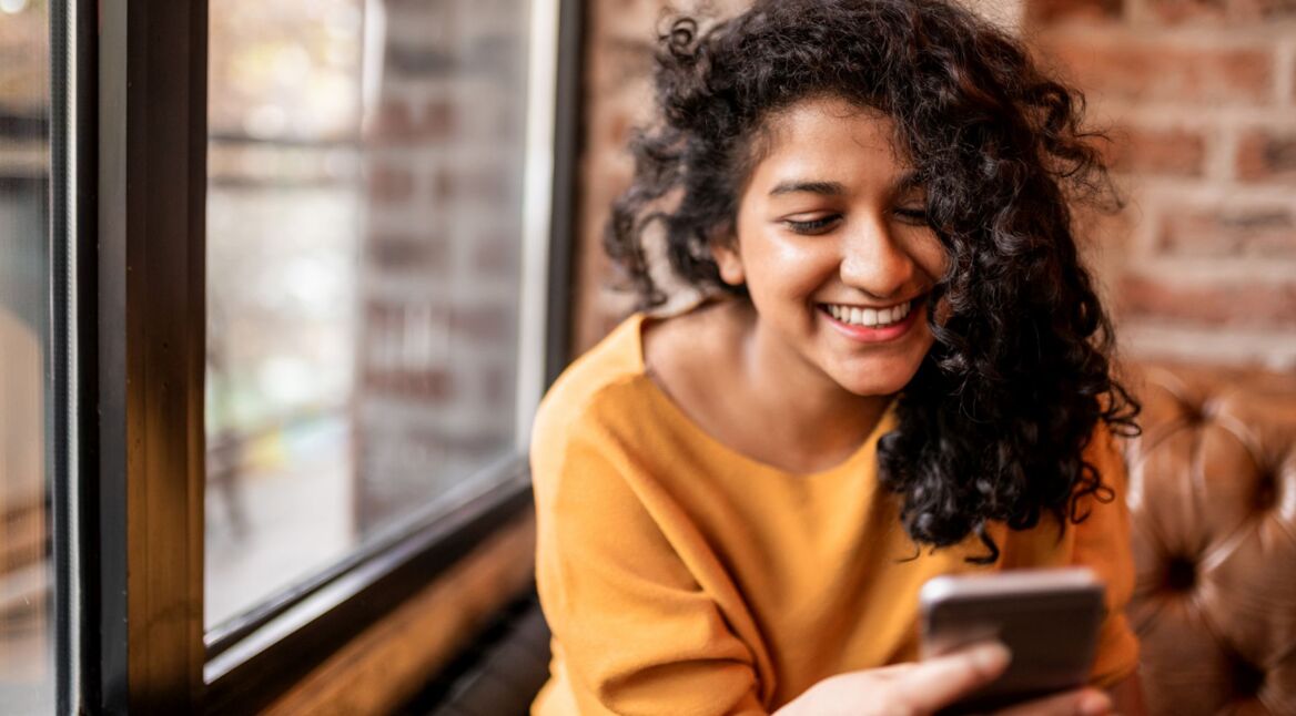 Frau überwacht Zyklus in der Fitbit-App am Smartphone