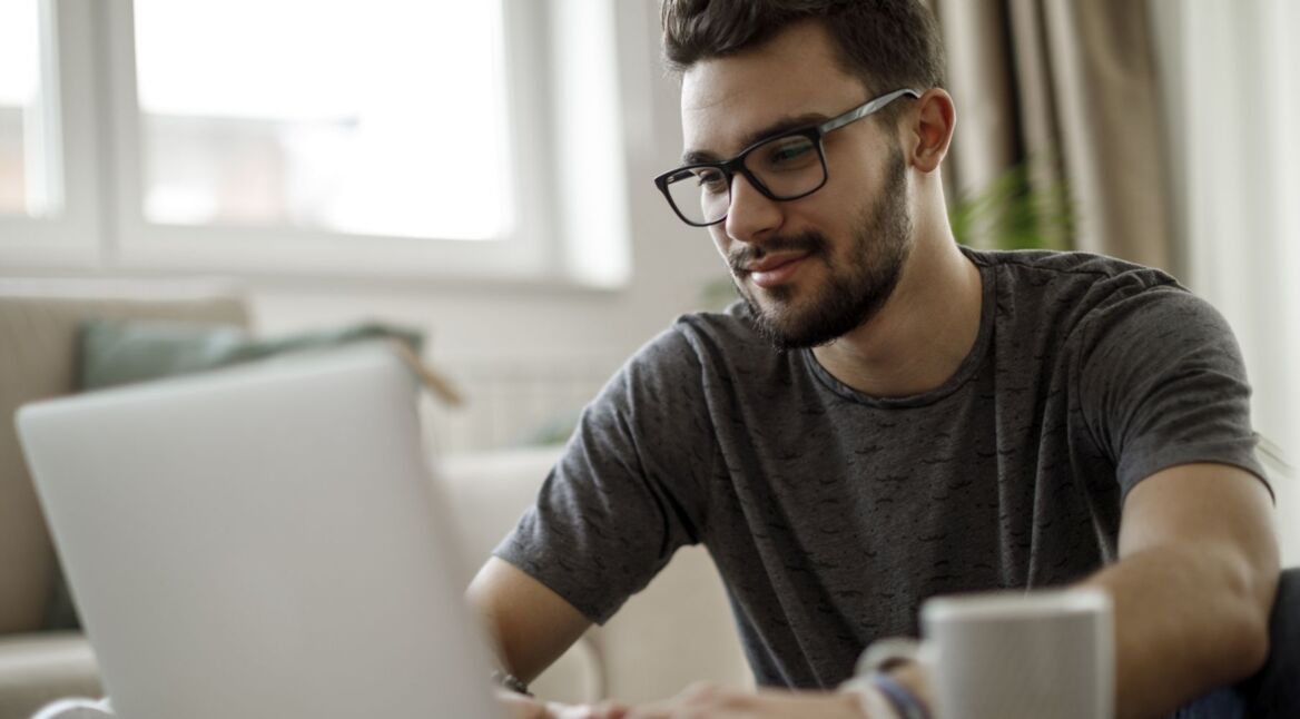 Mann sitzt am Laptop