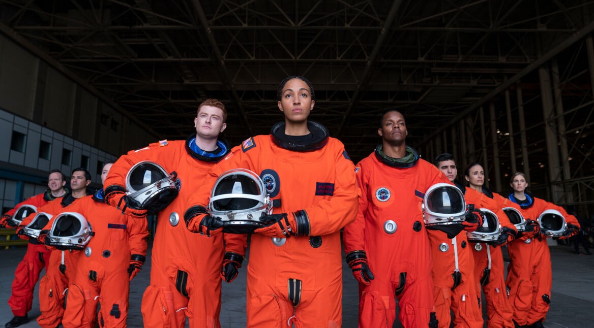 Ausschnitt aus der neuen SciFi-Comedy "Space Force", zu sehen sind Astronauten in orangen Raumanzügen mit ihren Helmen in der Hand.