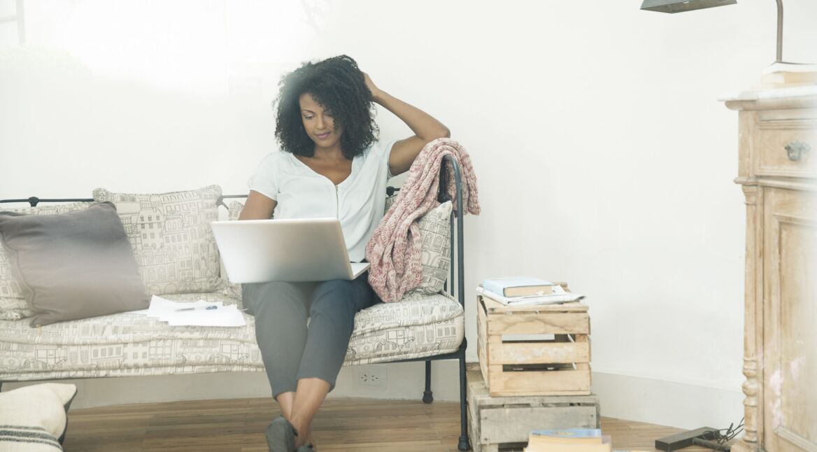Frau mit Laptop auf der Couch