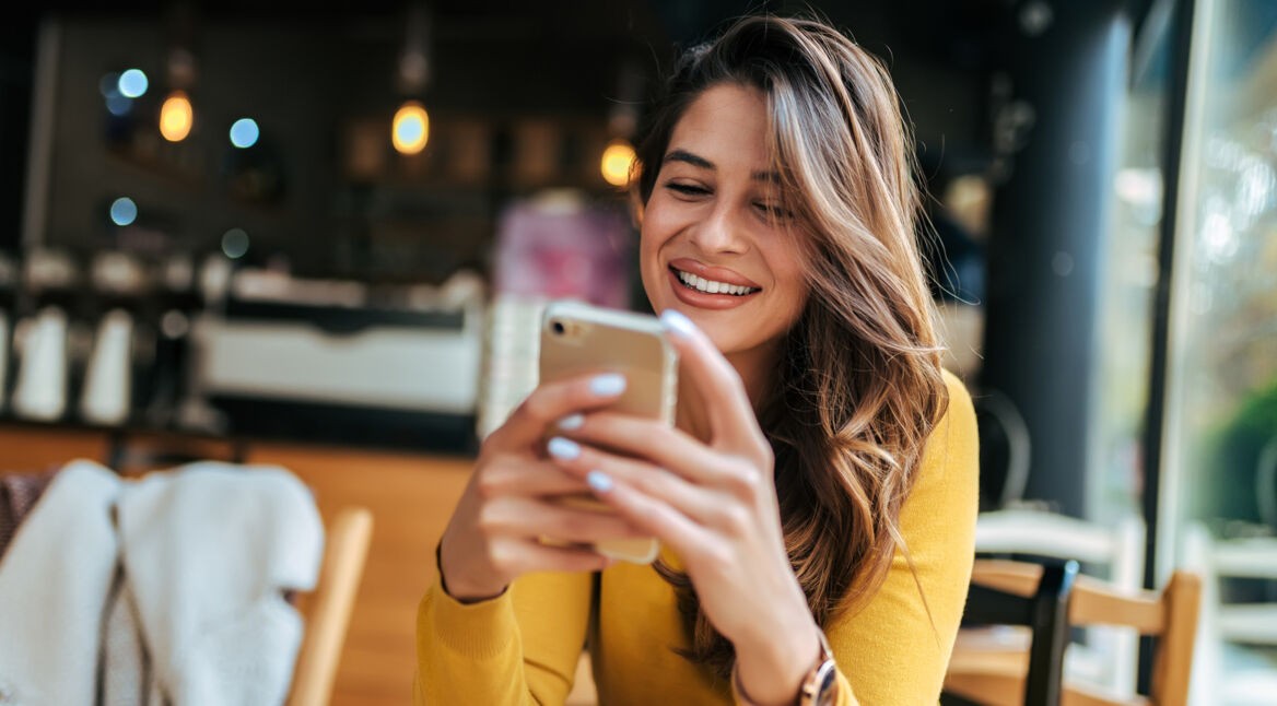Frau lachend mit Smartphone