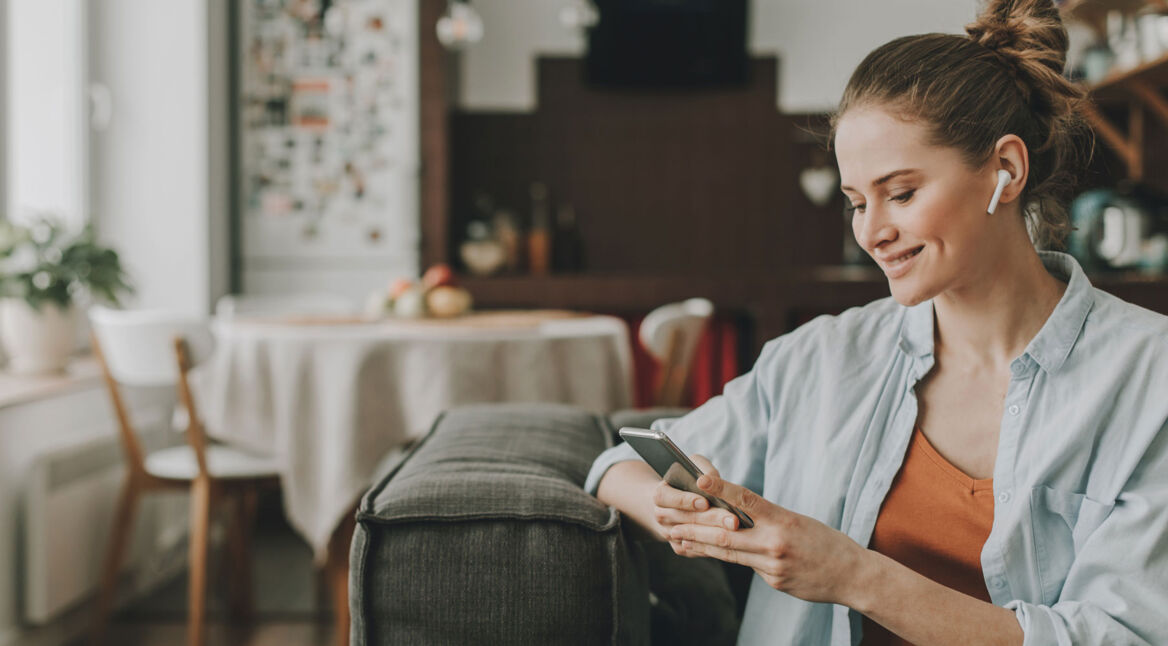 Frau mit Smartphone und AirPods