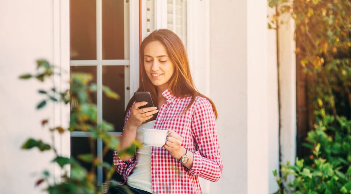 Junge Frau stellt HomeKit am iPhone ein.
