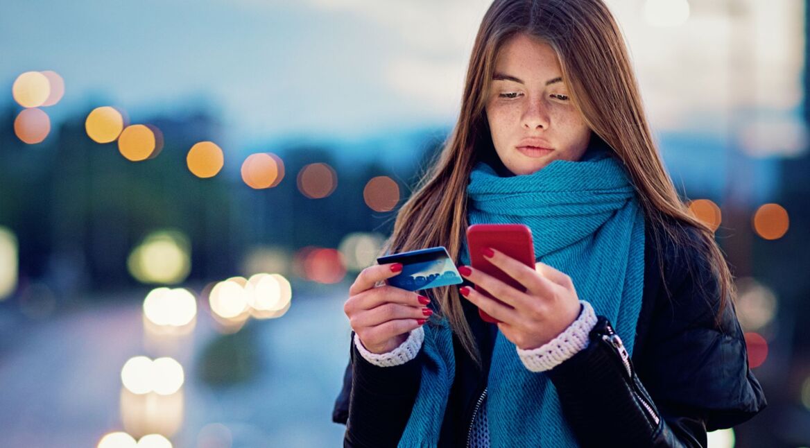 Frau richtet Google Pay mit Smartphone und Kreditkarte ein.