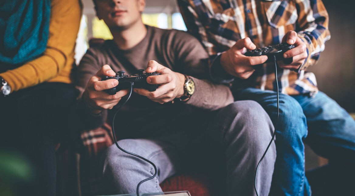 Drei junge Leute spielen ein Konsolen-Game