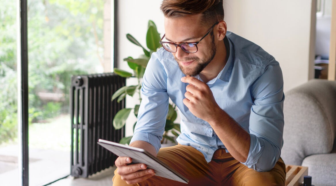 Junger Mann arbeitet mit seinem iPad