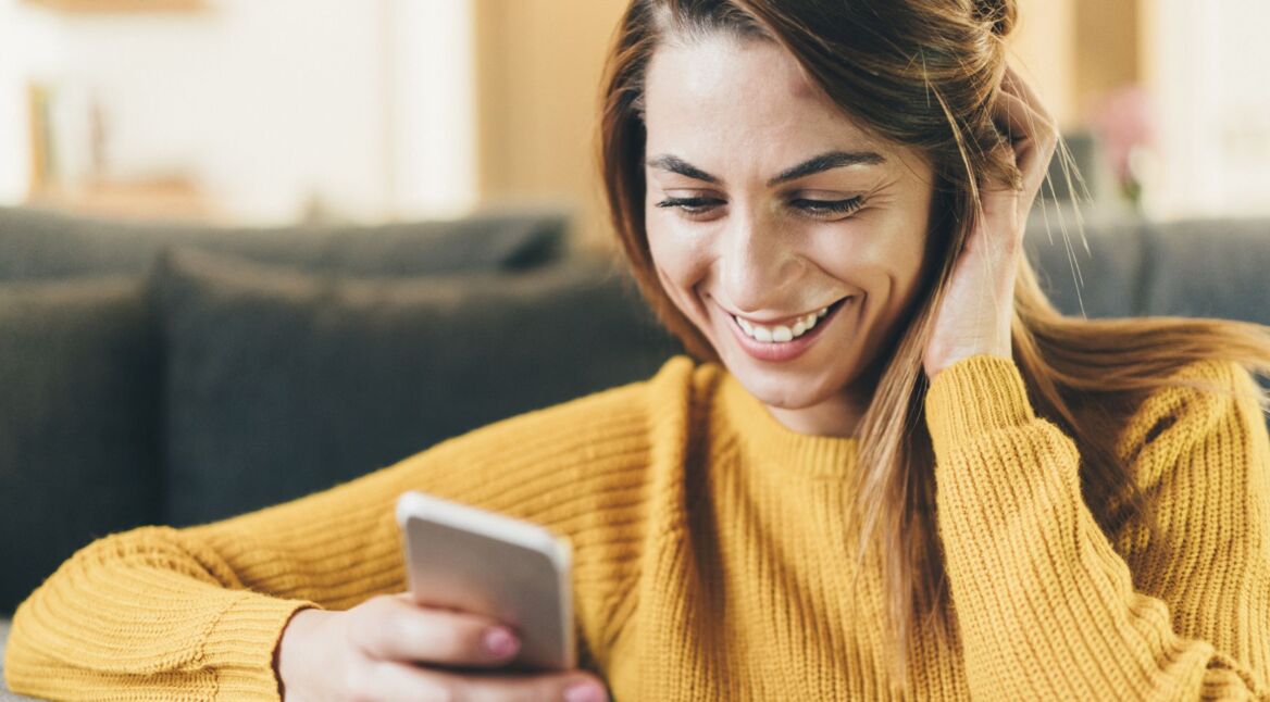 Frau löscht WhatsApp-Bilder am Handy.