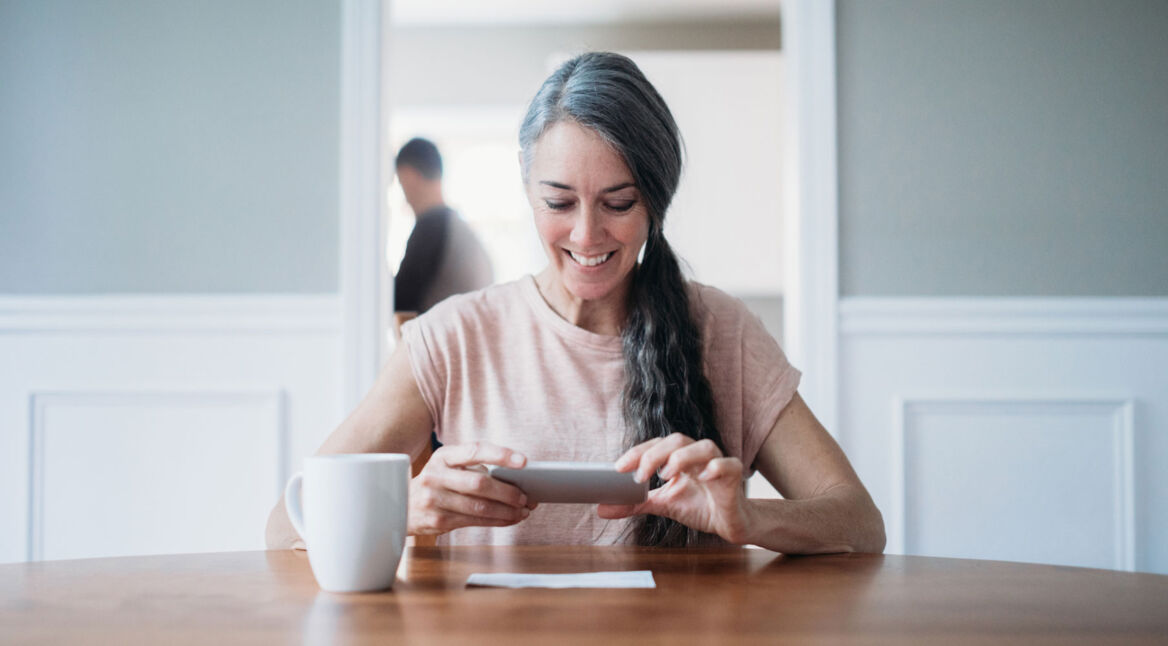 Frau scannt mit Smartphone eine Notiz ein