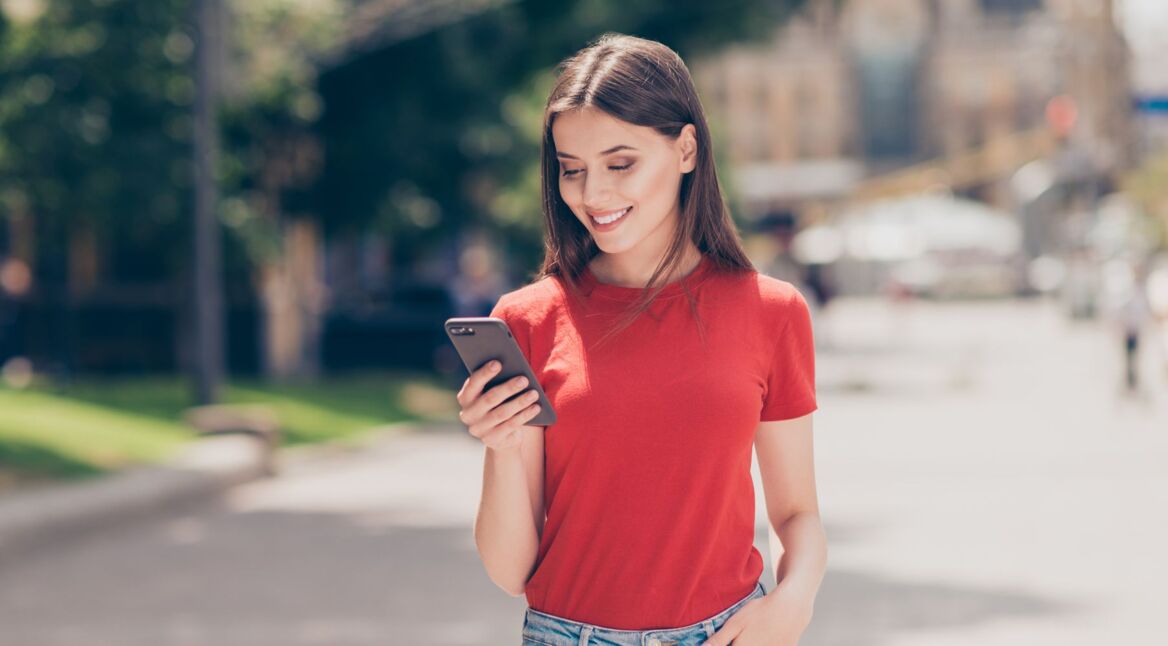 Junge Frau schaut auf ihr Android-11-Gerät.