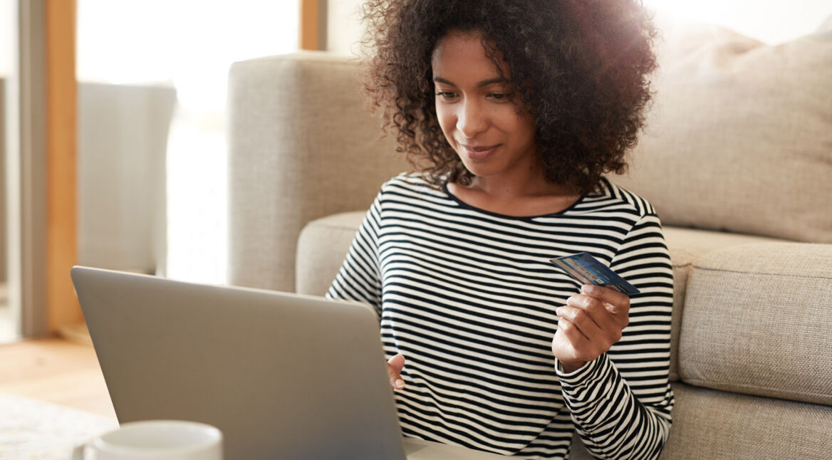 Frau überweist am Laptop Geld auf ihr PayPal-Konto