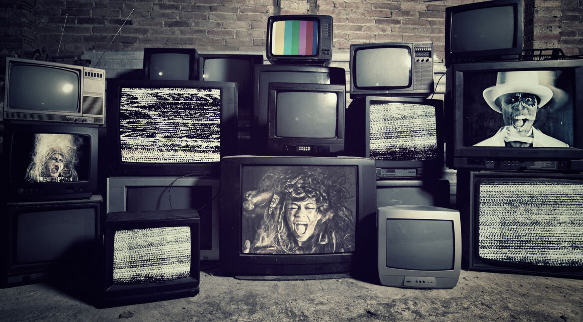 Mehrere Röhrenfernseher stehen gestapelt aufeinander, auf einigen sieht man schreiende Gesichter und eine Bildstörung.