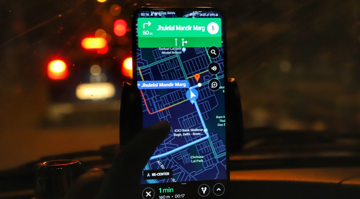 Smartphone mit Google Maps im Auto bei Nacht
