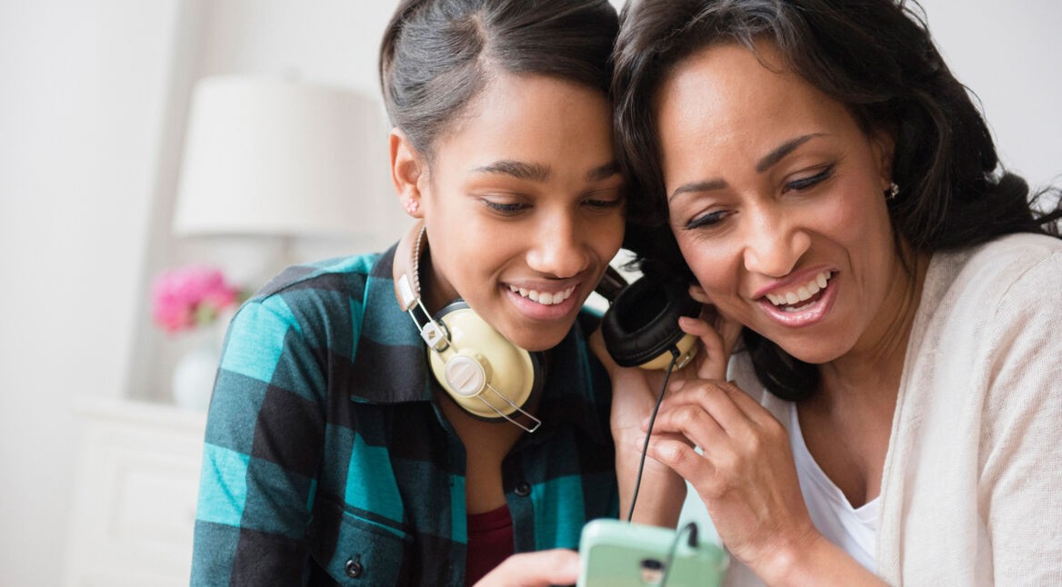 Mutter und Tochter hören Musik über Smartphone
