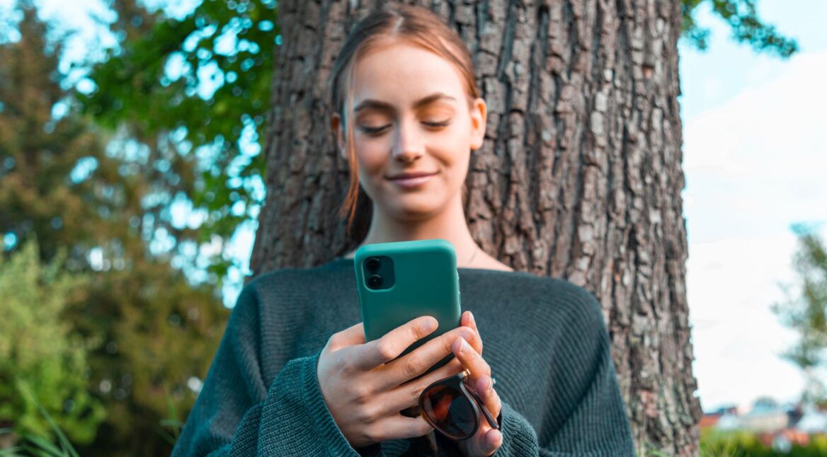 Frau schaltet Handy ein.