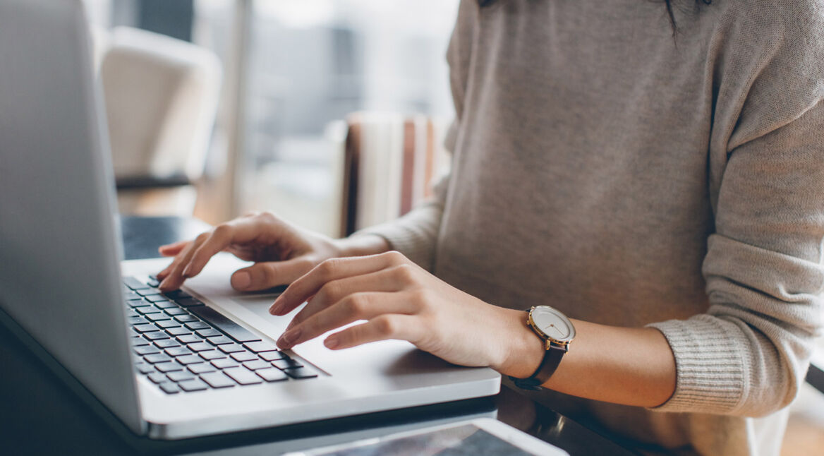 Frau schreibt E-Mail am Laptop
