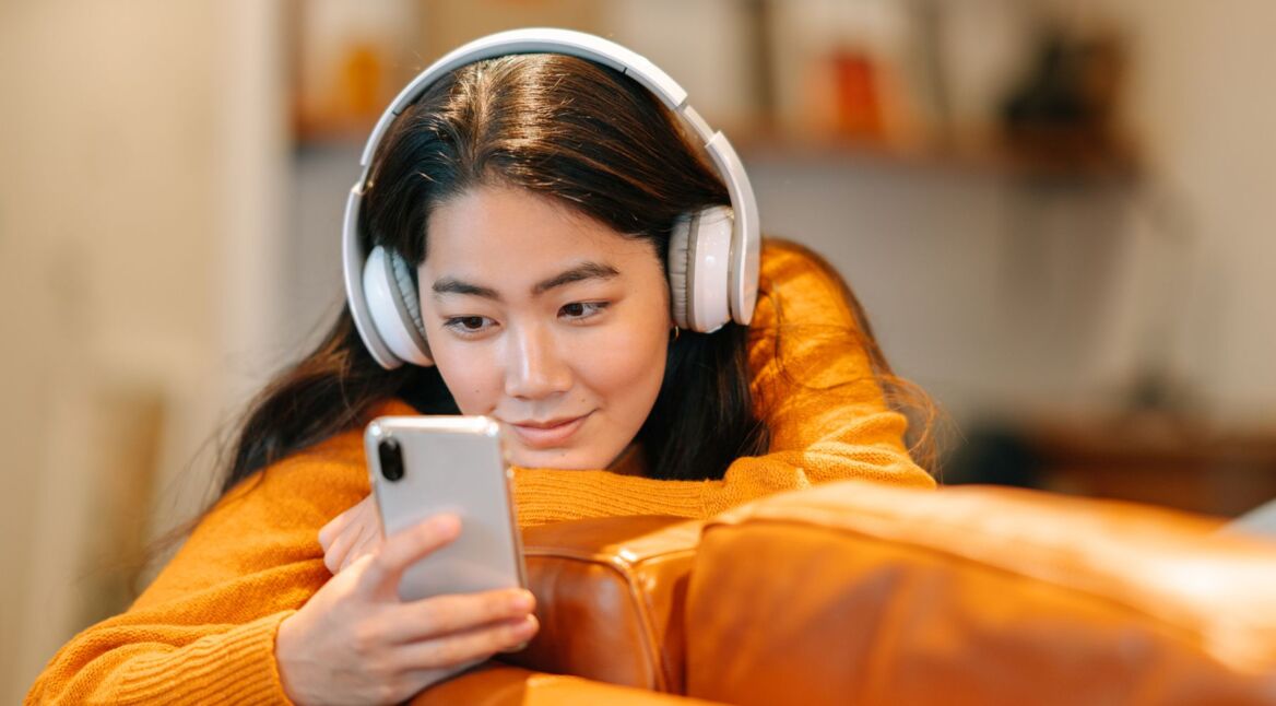 Frau hört Musik am Smartphone.