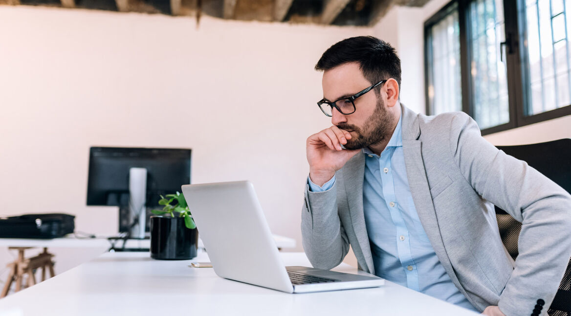 Man grübelt vor seinem Laptop