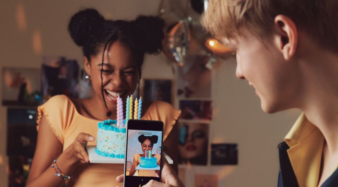 Junge macht Foto mit einem Mittelklasse-Smartphone.