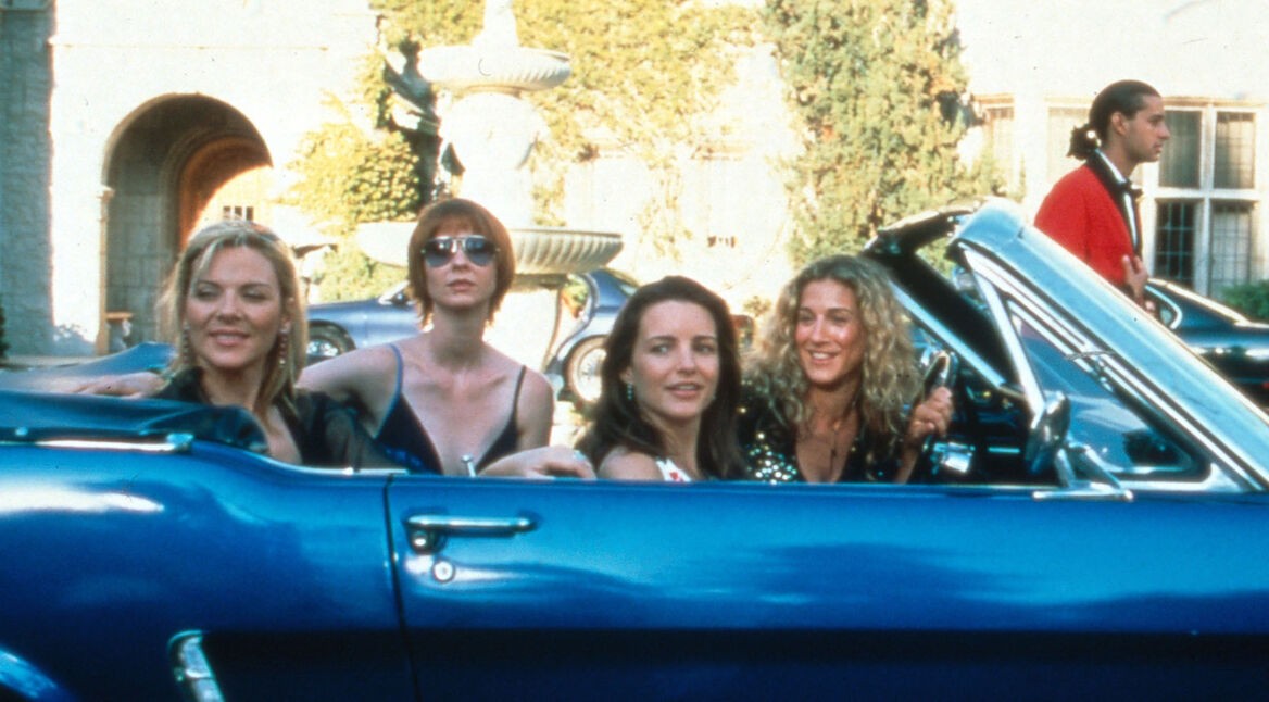 Die vier Hauptdarstellerinnen aus Sex and the City in einem blauen Cabrio