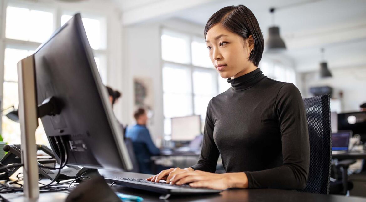 Frau arbeitet im Büro am PC