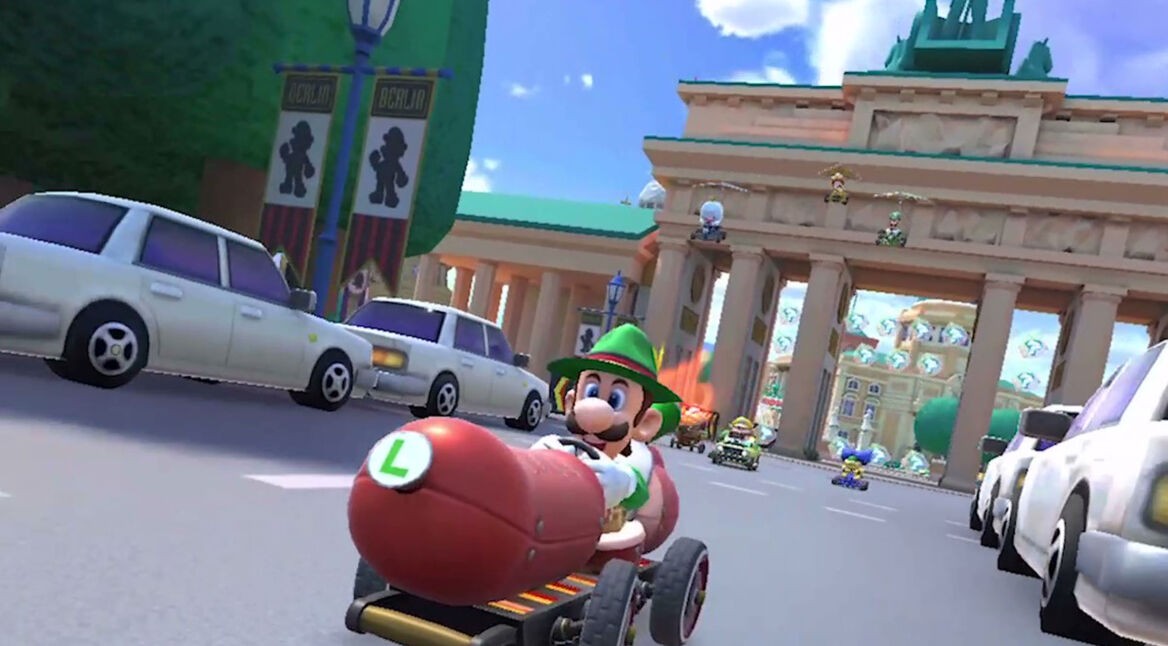Game-Screenshot aus "Mario Kart Tour": Luigi fährt mit seinem Wagen vor dem Brandenburger Tor in Berlin.