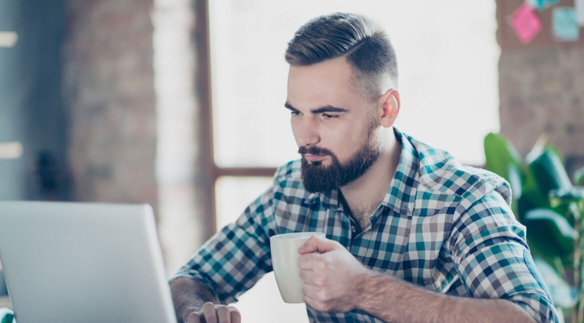 Mann arbeitet am Laptop