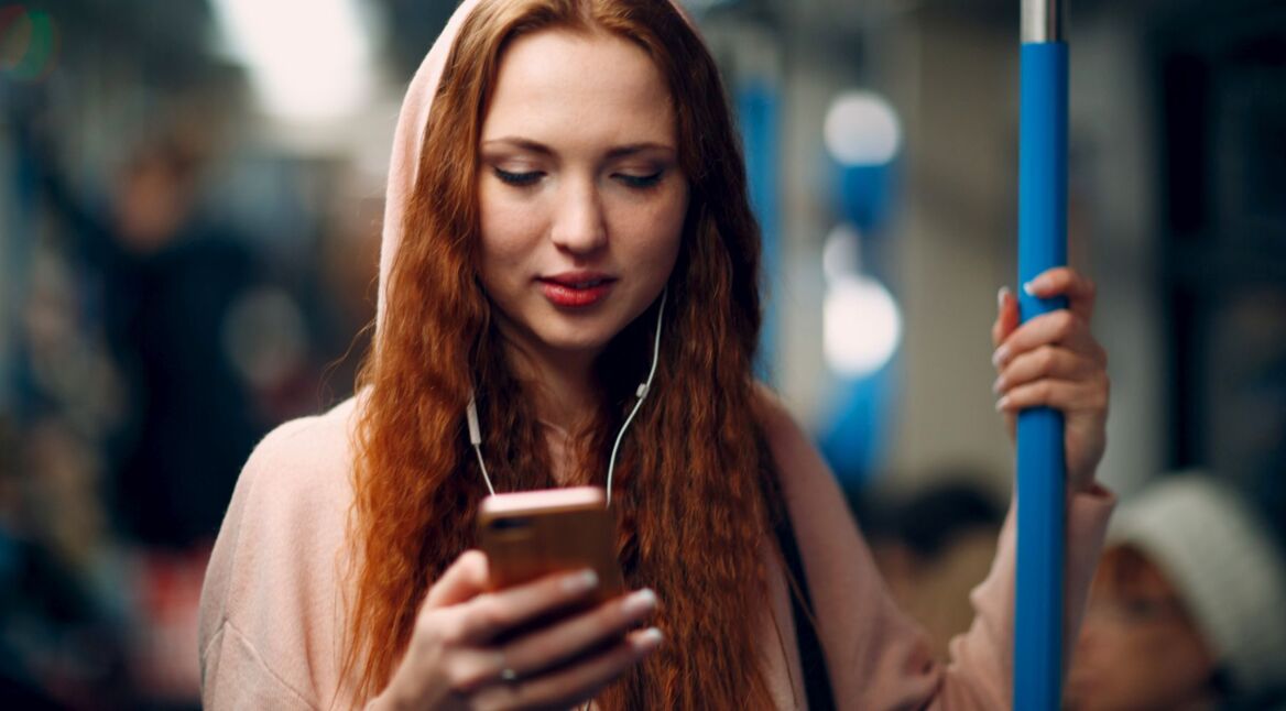 Frau hört Musik am Handy via Spotify.