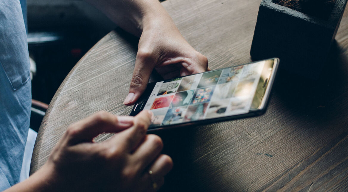 Mann scrollt durch Instagram-Beiträge